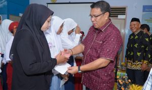 Penyerahan secara simbolis beasiswa prestasi oleh Sekretaris Daerah Kota Tidore Kepulauan kepada perwakilan Anak Anggota Penerima.