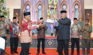 Walikota Tidore Kepulauan, Muhammad Sinen, SE (kanan) menyerahkan Piala Juara Umum kepada Camat Tidore Utara Ade Soninga pada Penutupan MTQ ke-31 Tingkat Kota Tidore Kepulauan Tahun 2026 di Aula Kie Matubu